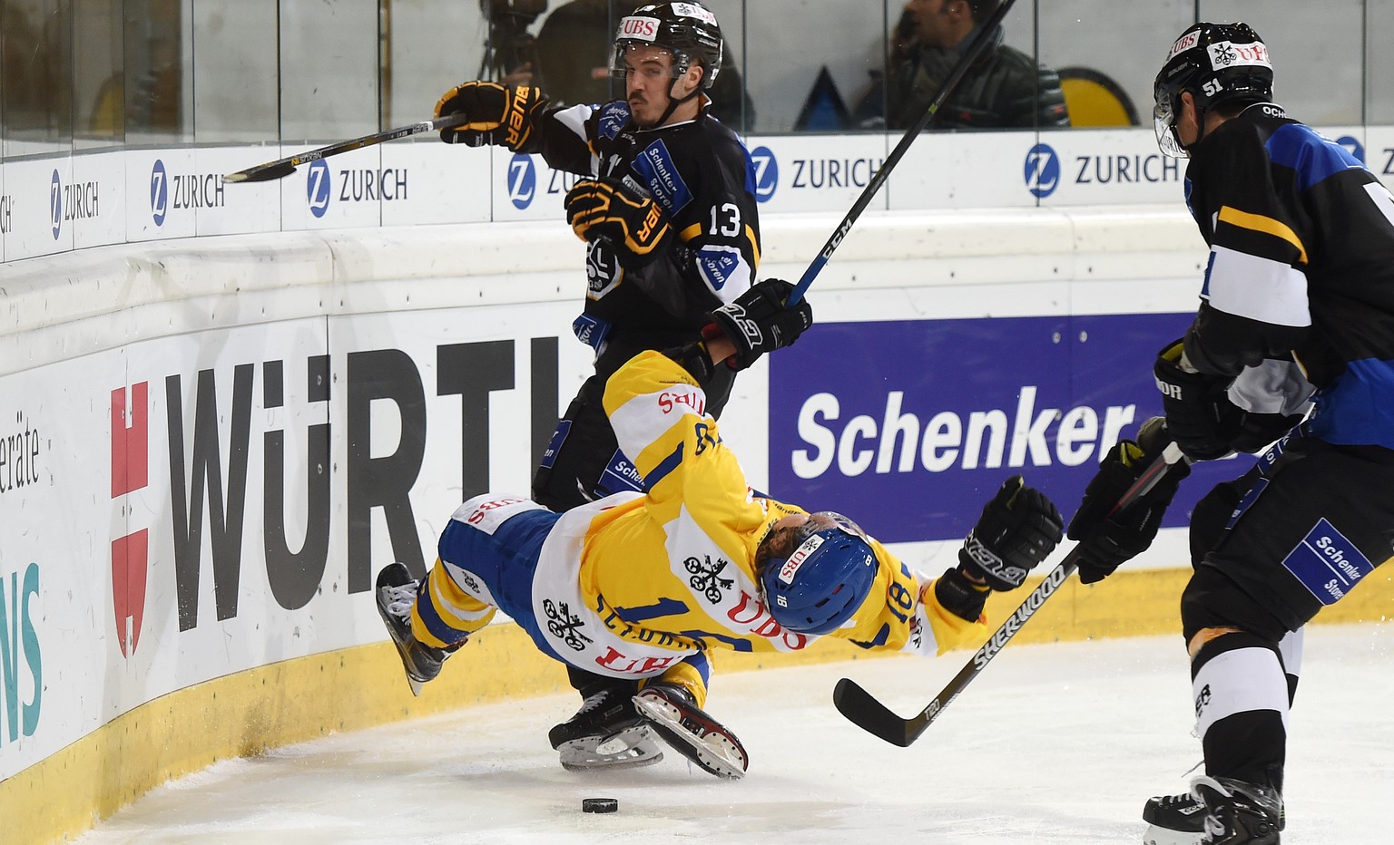 Davos Gregory Sciarono, left, goes out after a check against Luganos Alessio Bertaggia, right, during the game between Switzerlands HC Lugano and Switzerlands HC Davos at the 90th Spengler Cup ice hoc ...