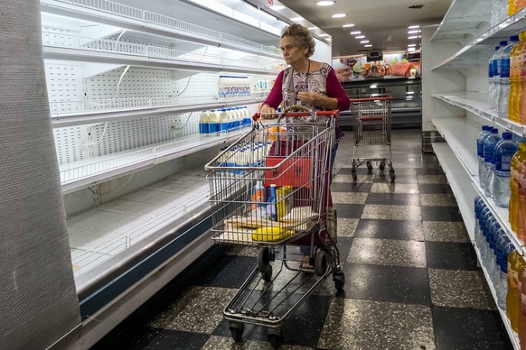 epa07016100 A person browses through nearly empty supermarket shelves in Caracas, Venezuela, 12 September 2018. Economic activity in Venezuela has been reduced by 50.61 percent since President Nicolas ...