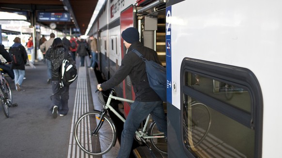 A man steps out of an InterCity train of the Swiss Federal Railways SBB in Biel, Switzerland, with his bike, on November 27, 2009. (KEYSTONE/Gaetan Bally) 

Ein Mann verlaesst am 27. November 2009 im  ...