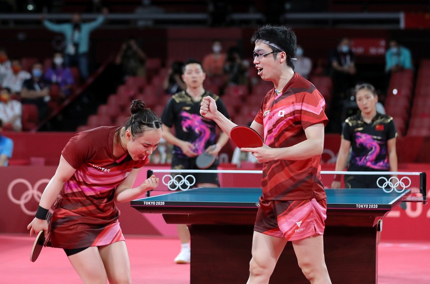 epa09368060 Mima Ito (L) and Jun Mizutani (center-R) of Japan, backed by Xin Xu (center-L) and .Shiwen Liu (R) of China, react at the end of the Mixed Doubles Gold Medal Table Tennis Match China vs Ja ...