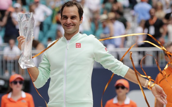 Roger Federer, of Switzerland, poses with the trophy after defeating John Isner in the singles final of the Miami Open tennis tournament, Sunday, March 31, 2019, in Miami Gardens, Fla. Federer won 6-1 ...