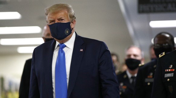 President Donald Trump wears a face mask as he walks down a hallway during a visit to Walter Reed National Military Medical Center in Bethesda, Md., Saturday, July 11, 2020. (AP Photo/Patrick Semansky ...