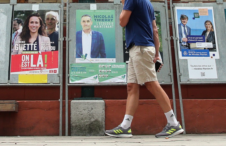 A man looks at posters advertising the upcoming regional election in Saint Jean de Luz southwestern France, Friday, June 18, 2021. Regional election will take place on June 20 and 27 throughout France ...