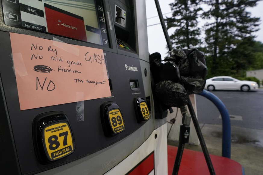 A hand written sign is posted on a gas pump, showing that the service station is out of all grades of fuel Wednesday, May 12, 2021, in Charlotte, N.C. Several gas stations in the Southeast reported ru ...
