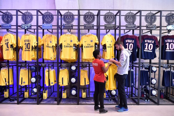 epaselect epa06124011 Employees of the official Paris Saint-Germain (PSG) store display the new jerseys of Brazilian striker Neymar Jr (not pictured) on sale in Paris, France, 04 August 2017. Neymar J ...