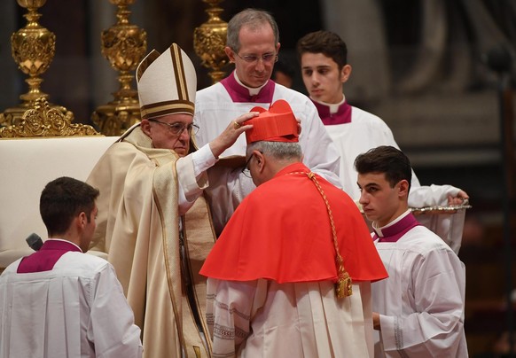 epa05637851 Pope Francis (2-L) places the red three-cornered biretta hat on the head of new Cardinal Baltazar Enrique Porras Cardozo (C), Archbishop of Merida in Venezuela, during the Consistory cerem ...