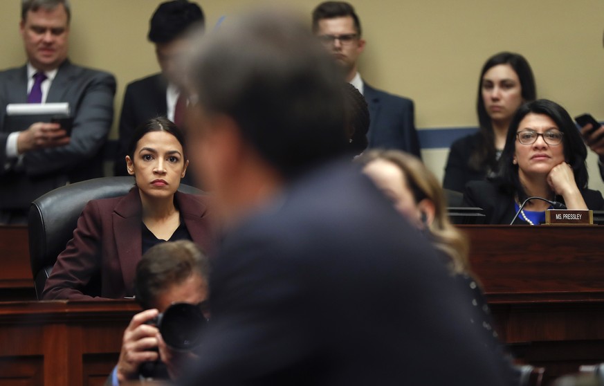 Committee members Rep. Alexandria Ocasio-Cortez, D-N.Y.,, left, and Rep. Rashida Tlaib, D-Mich., right, listen to Michael Cohen, center, President Donald Trump&#039;s former lawyer, testimony before t ...