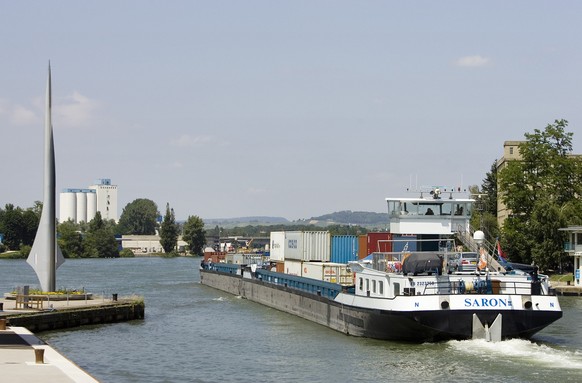 Das Containerschiff Saron faehrt beim Hafen Kleinhueningen in Basel am Denkmal des Dreilaenderecks vorbei flussabwaerts, am 23. Juni 2006. (KEYSTONE/Gaetan Bally) 

The container ship Saron passing by ...