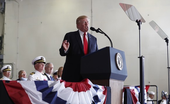 President Donald Trump speaks during the commissioning ceremony of the aircraft carrier USS Gerald R. Ford (CVN 78) at Naval Station Norfolk, Va., Saturday, July, 22, 2017. Seated behind the president ...