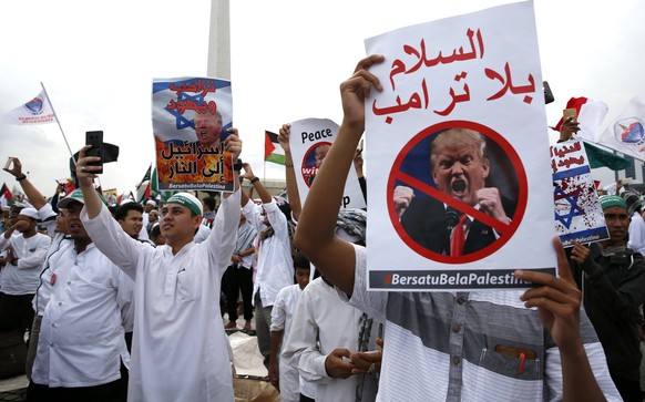 epa06394627 Indonesian Muslim activists hold placards and shout slogans during a protest against US President Donald J.Trump&#039;s decision to recognize Jerusalem as capital of Israel at the National ...