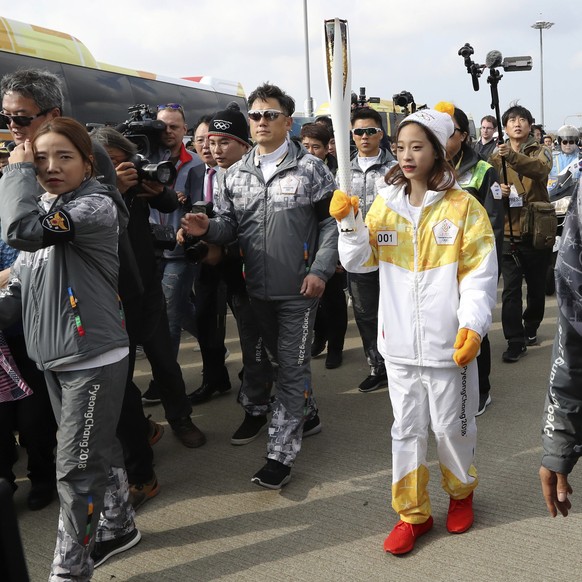 First torch bearer, South Korean figure skater You Young, center, carries an Olympic torch during the Olympic Torch Relay at Incheon Bridge in Incheon, South Korea, Wednesday, Nov. 1, 2017. The Olympi ...