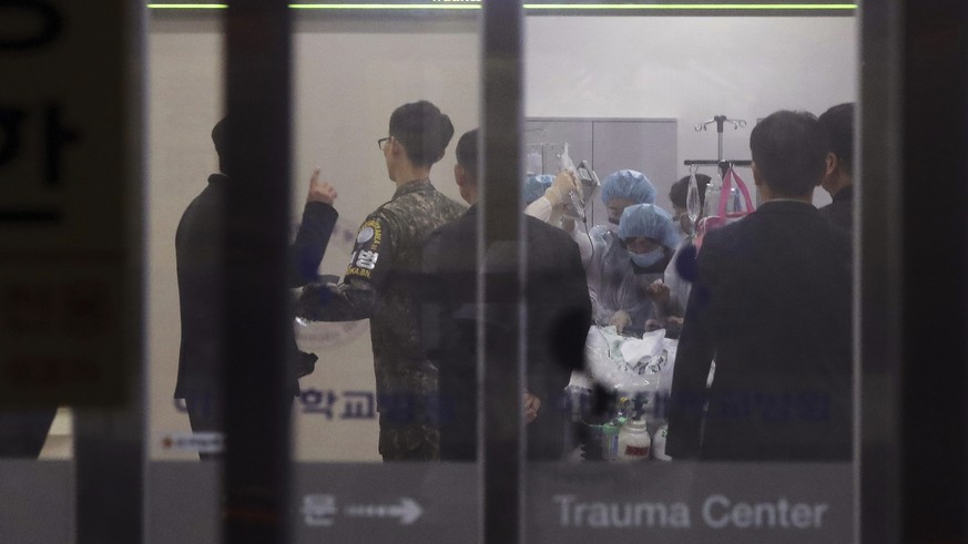 FILE - in this Nov. 13, 2017, file photo, a South Korean army soldier, second from left, is seen as medical members treat an unidentified injured person, believed to be a North Korean soldier, at a ho ...
