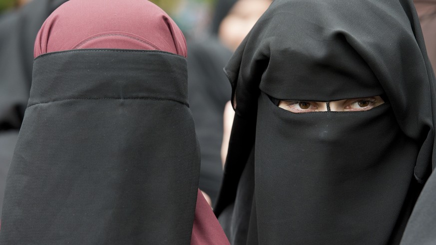 FILE - In this June 28, 2014 file photo veiled women attend a speech by preacher Pierre Vogel, in Offenbach, near Frankfurt, Germany. A law that forbids any kind of full-face covering, including Islam ...