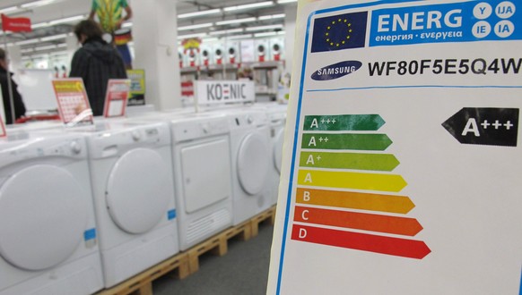 ARCHIV - Ein Hinweisschild mit Ausweisung der Energieeffizienzklasse steht am 13.05.2014 in München (Bayern) in einem Großmarkt für Elektroartikel. Verbraucher sollen besonders energiesparende Geräte  ...