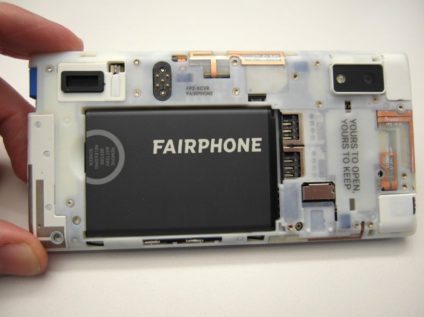 Frisch aus dem Karton geholt, sieht das Fairphone 2 sehr nackt aus, die Rückseite liegt vollkommen ungeschützt und offen da. Ein Motto der Firma ist an der Oberseite zu lesen: «Yours To Open. Yours To ...