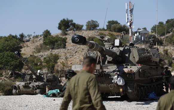 epa07792033 Israeli soldiers stand next to their armoured fighting vehicle (AFV) at the Israeli-Syrian border, in the Golan Heights, north of Israel, 25 August 2019. The Israel Defense Forces (IDF) co ...