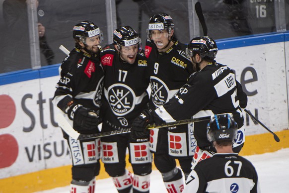 Lugano&#039;s players Giovanni Morini, Luca Fazzini and Reto Suri, from left, cheer after a goal during the preliminary round game of National League (NLA) Swiss Championship 2020/21 between HC Lugano ...