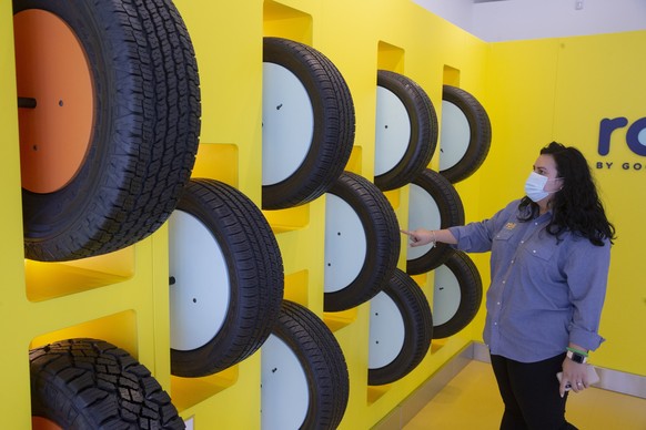 epa08613236 An employee gestures beside sample tires at a Roll by Goodyear location in Washington, DC, USA, 19 August 2020. US President Donald J. Trump has called on people to boycott tires made by G ...