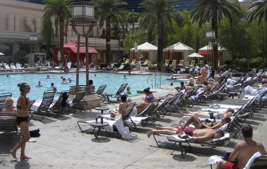 FILE - In this file photo dated May 2, 2009, holiday makers sunbath around a hotel pool, at an unknown location. Travel company Thomas Cook said Monday Jan. 29, 2018, it is offering to reserve poolsid ...