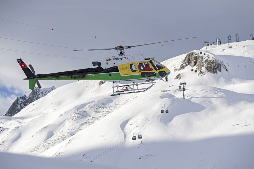 epa08090909 Rescue forces and helicopters search for missing persons after an avalanche swept down a ski piste in the central town of Andermatt in canton Uri, Switzerland, Switzerland, 26 December 201 ...