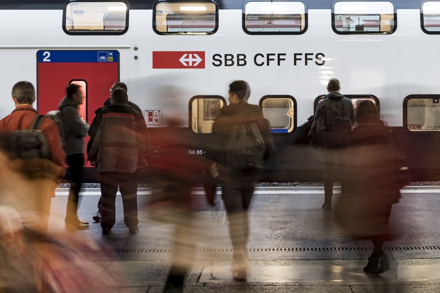 Des voyageurs et des pendulaires circulent sur un quai devant un train CFF SBB ce mercredi 14 novembre 2018 dans la gare de Lausanne. (KEYSTONE/Jean-Christophe Bott)