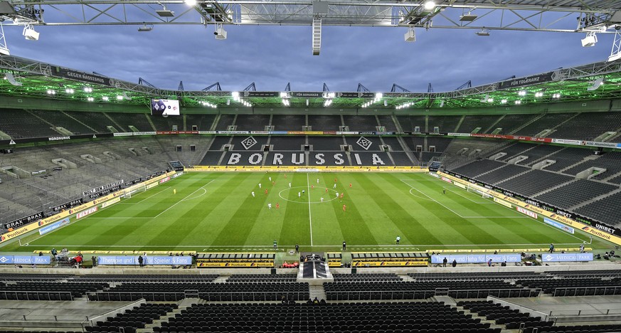 Players run for the ball in an empty stadium during the German Bundesliga soccer match between Borussia Moenchengladbach and 1.FC Cologne in Moenchengladbach, Germany, Wednesday, March 11, 2020. It is ...