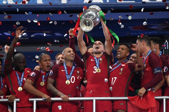 epa05419715 Pepe (C) of Portugal lifts the trophy after winning the UEFA EURO 2016 Final match against France at Stade de France in Saint-Denis, France, 10 July 2016. 


(RESTRICTIONS APPLY: For ed ...