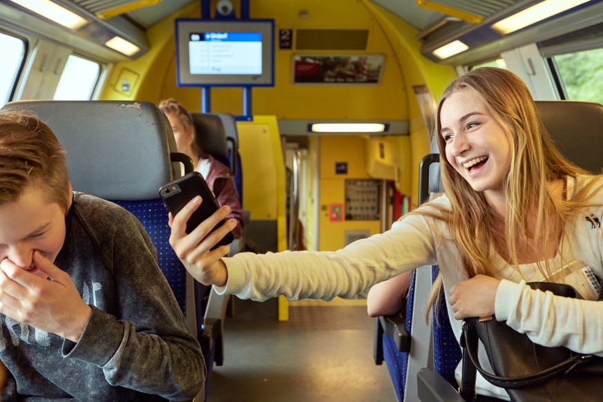 Adolescents kid around with their smart phone while commuting in the city train between Zurich and Zug, Switzerland, on June 16, 2015. (KEYSTONE/Christof Schuerpf)

Jugendliche albern mit dem Smartpho ...