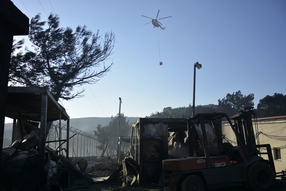 An helicopter operates over the Moria refugee camp during a fire on the northeastern Aegean island of Lesbos, Greece, on Wednesday, Sept. 9, 2020. A fire swept through Greece&#039;s largest refugee ca ...