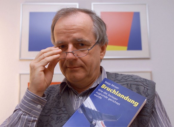 Aviatikexperte und Publizist Sepp Moser posiert am Dienstag, 4. Dezember 2001, in Winkel ZH mit seinem Buch &quot;Bruchlandung - Wie die Swissair zugrunde gerichtet wurde&quot;, das dieser Tage erschi ...