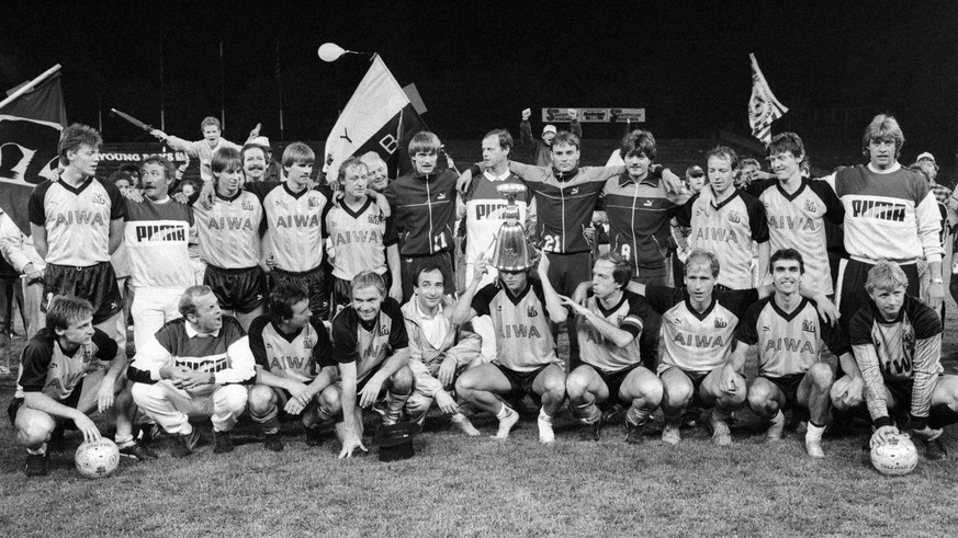 Die Mannschaft der Berner Young Boys feiert den Sieg der Meisterschaft beim Spiel gegen den FC Zuerich am 27. Mai 1986 in Bern. YB Stuermer Lars Lunde, Mitte, stuelpt sich vor Begeisterung den Meister ...