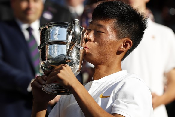 epa06891496 Chun Hsin Tseng of Taiwan lifts the championship trophy after beating Jack Draper of Britain in the juniors singles final of the Wimbledon Championships at the All England Lawn Tennis Club ...