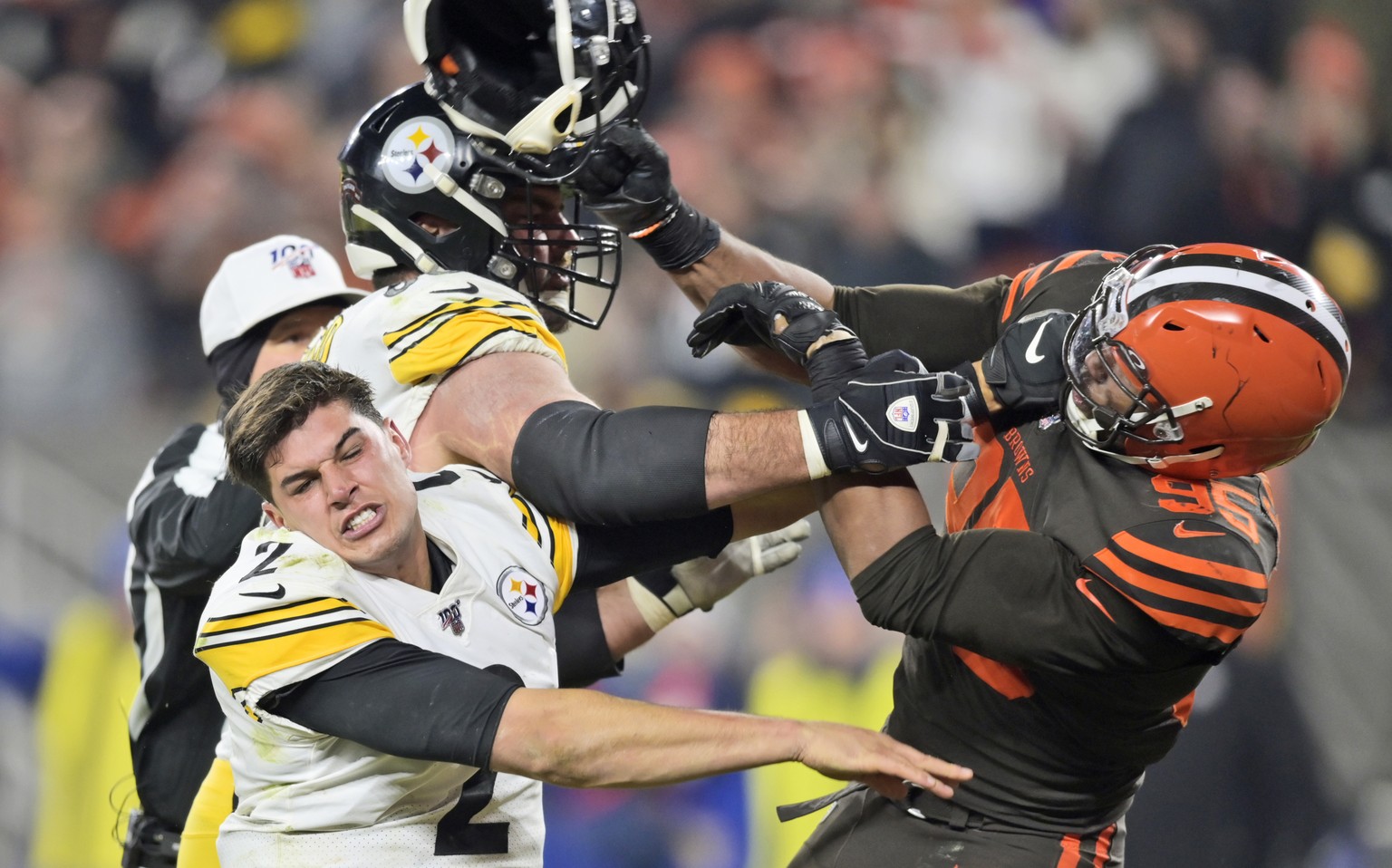 Cleveland Browns defensive end Myles Garrett (95) hits Pittsburgh Steelers quarterback Mason Rudolph (2) with a helmet during the second half of an NFL football game Thursday, Nov. 14, 2019, in Clevel ...