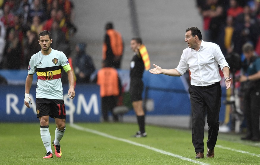 Belgium coach Marc Wilmots gestures while team captain Eden Hazard walks by during the Euro 2016 quarterfinal soccer match between Wales and Belgium, at the Pierre Mauroy stadium in Villeneuve dAscq, ...