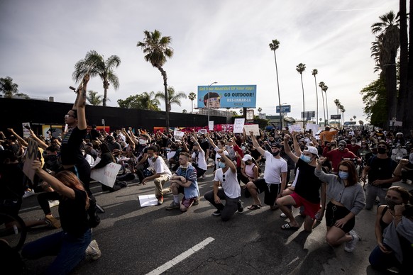 epa08459542 Protesters take a knee on Sunset Boulevard during a protest following the death of George Floyd, in Hollywood, California, USA, 01 June 2020. A bystander&#039;s video posted online on 25 M ...