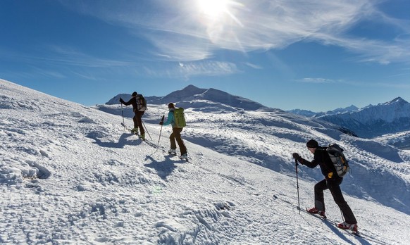 Skitourengaenger geniessen den Aufstieg durch die frisch verschneite Winterlandschaft auf dem Dreibuendensteins oberhalb Chur, am Freitag, 29. November 2013. (KEYSTONE/Arno Balzarini)