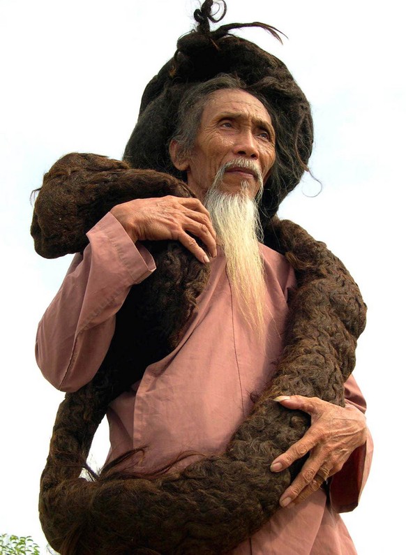 Tran Van Hay, 67, from Chau Thanh district in the southern Kien Giang province of Vietnam poses for a photo showing his over 6.2 meters (20.34 feet) long hair Saturday June 19, 2004. Hay has his name  ...