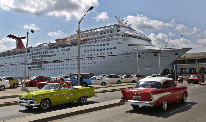 epa07531084 Two classic American cars pass in front of a cruise ship anchored in the port of Havana, Cuba, 26 April 2019. EPA/Yander Zamora