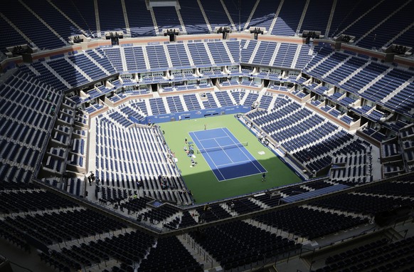 FILE - In this Aug. 27, 2017, file photo, players practice for the U.S. Open tennis tournament at Arthur Ashe Stadium in New York. When he first contemplated the prospect of a U.S. Open without fans b ...