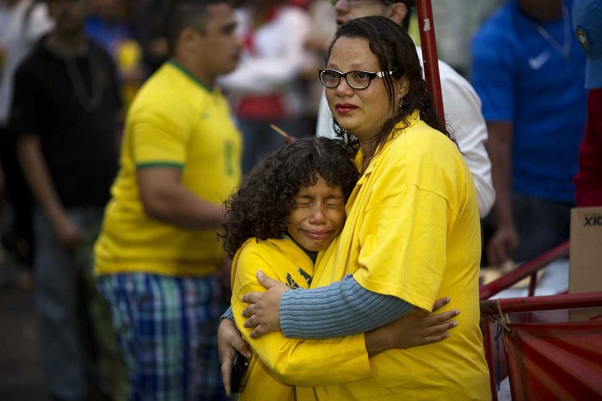 Brazil soccer fans embrace as they watch their team lose to Germany via a live telecast of the World Cup semifinal game in Sao Paulo, Brazil, Tuesday, July 8, 2014. (AP Photo/Rodrigo Abd)
