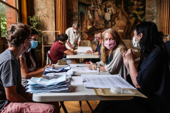 epa08514941 Volunteers wearing face masks count ballots at a polling station in the city hall of the 14th district during the second round of the French Municipal elections in Paris, France, 28 June 2 ...