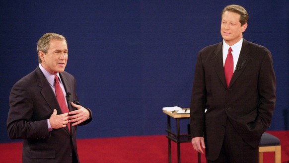 FILE - In this Oct. 17, 2000 file photo, Republican presidential candidate, Texas Gov. George W. Bush, left, speaks as Democratic presidential candidate Vice President Al Gore watches during their thi ...