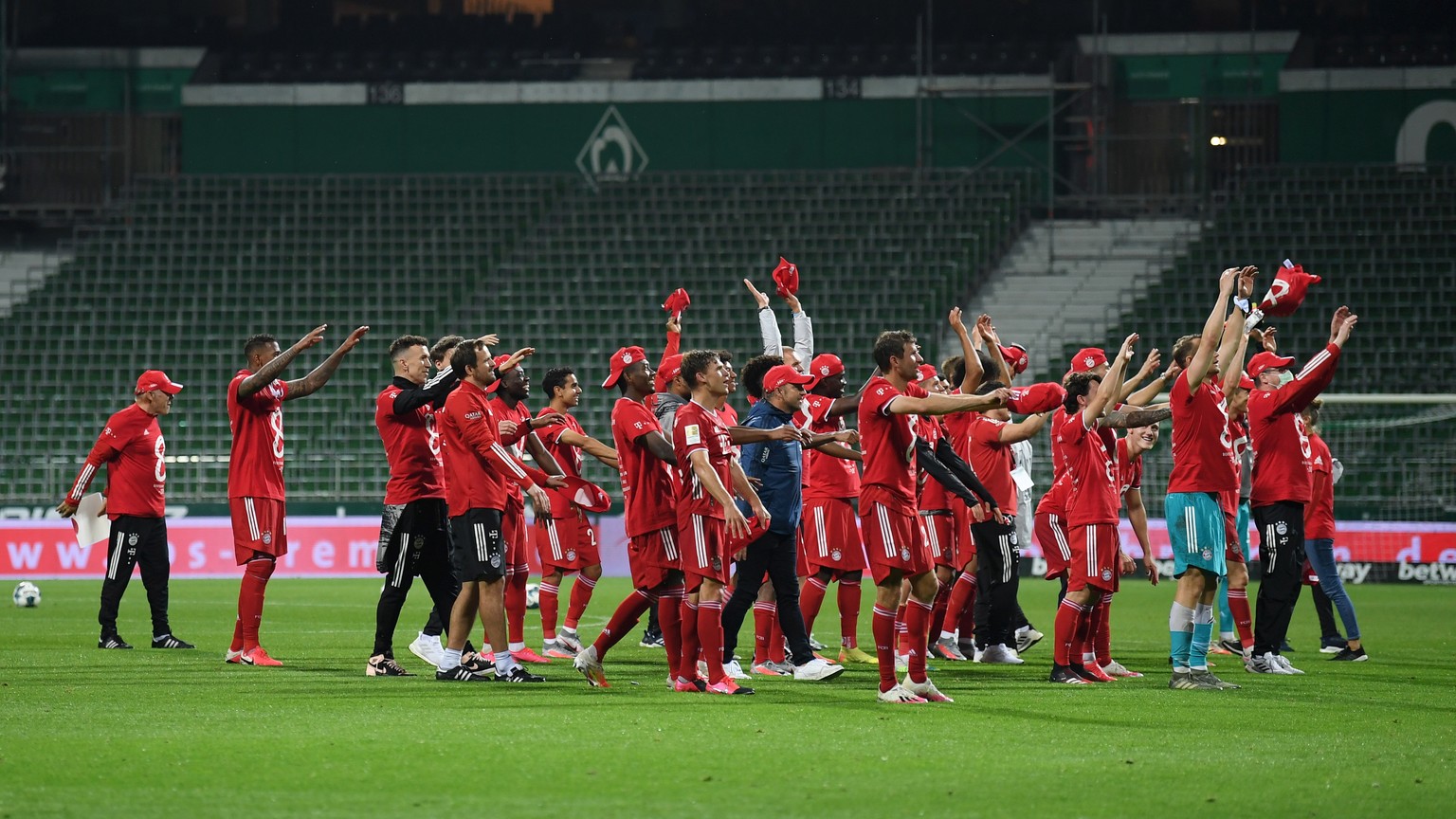 epa08489397 Players of Bayern Munich celebrate securing the Bundesliga title in front of empty stands following the victory in the German Bundesliga soccer match between SV Werder Bremen and FC Bayern ...