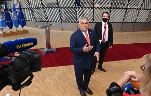 epa09298473 Hungary&#039;s Prime Minister Viktor Orban (C) gestures as he addresses media representatives as he arrives on the first day of a European Union (EU) summit at the European Council Buildin ...
