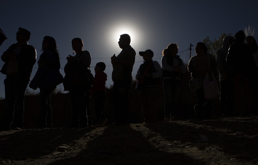 People stand in line for their chance to view the solar eclipse through a telescope in an astronomical complex at the University Mayor de San Andres in La Paz, Bolivia, Tuesday, July 2, 2019. A solar  ...