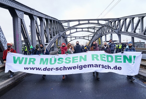 22.11.2020, Berlin: Wir muessen reden!� steht auf dem Banner, das Teilnehmer einer Demonstration, die als �Schweigemarsch� bezeichnet wird und sich gegen die Corona-Politik der Bundesregierung richtet ...