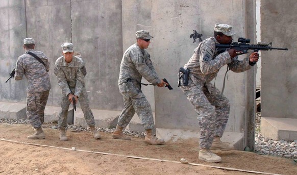 epa01957574 US soldiers conduct a raid as part of a military training with Iraqi soldiers at a military base in Karbala, southern Iraq on 07 December 2009. EPA/ALAA AL-SHEMAREE