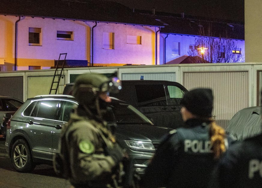 Blue police lights flash to illuminate a house where special police forces attend the scene in Hanau, Germany Thursday, Feb. 20, 2020. Several people were killed at locations when shots were fired in  ...
