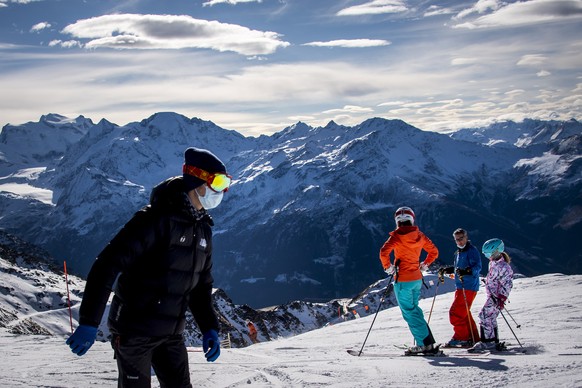 epa08906526 (FILE) - Skiers wearing protective masks ski on a slope in the Valais ski area in Verbier, Switzerland, 28 November 2020 (reissued 27 December 2020). A spokesman for the municipality to wh ...