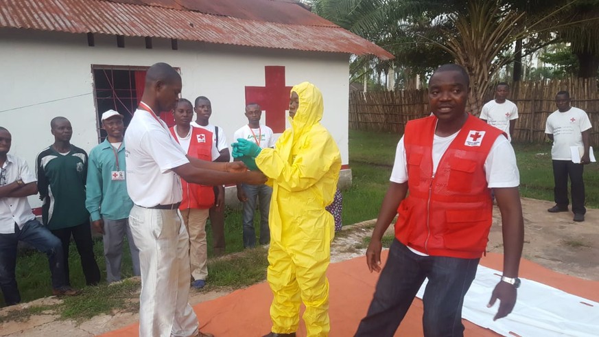 epa06754174 A handout photo made available by The International Federation of Red Cross and Red Crescent (IFRC) shows health workers in protective clothing in Mbandaka, The Democratic Republic Of The  ...
